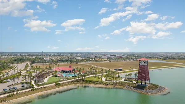 an aerial view of residential building with outdoor space lake and trees all around