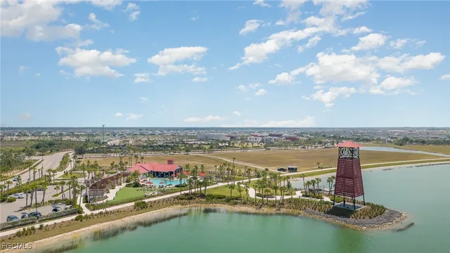 an aerial view of residential building with outdoor space lake and trees all around
