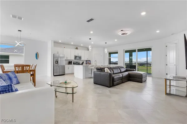 a living room with furniture and a view of kitchen