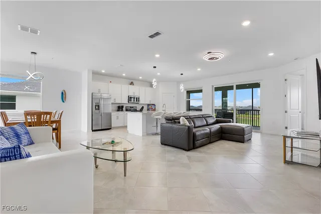 a living room with furniture and a view of kitchen