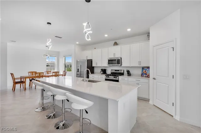 a kitchen with kitchen island appliances cabinets and chair
