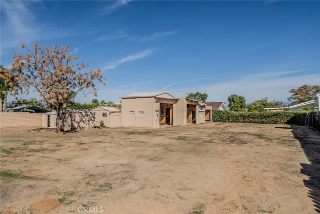 a view of house with yard and sitting area