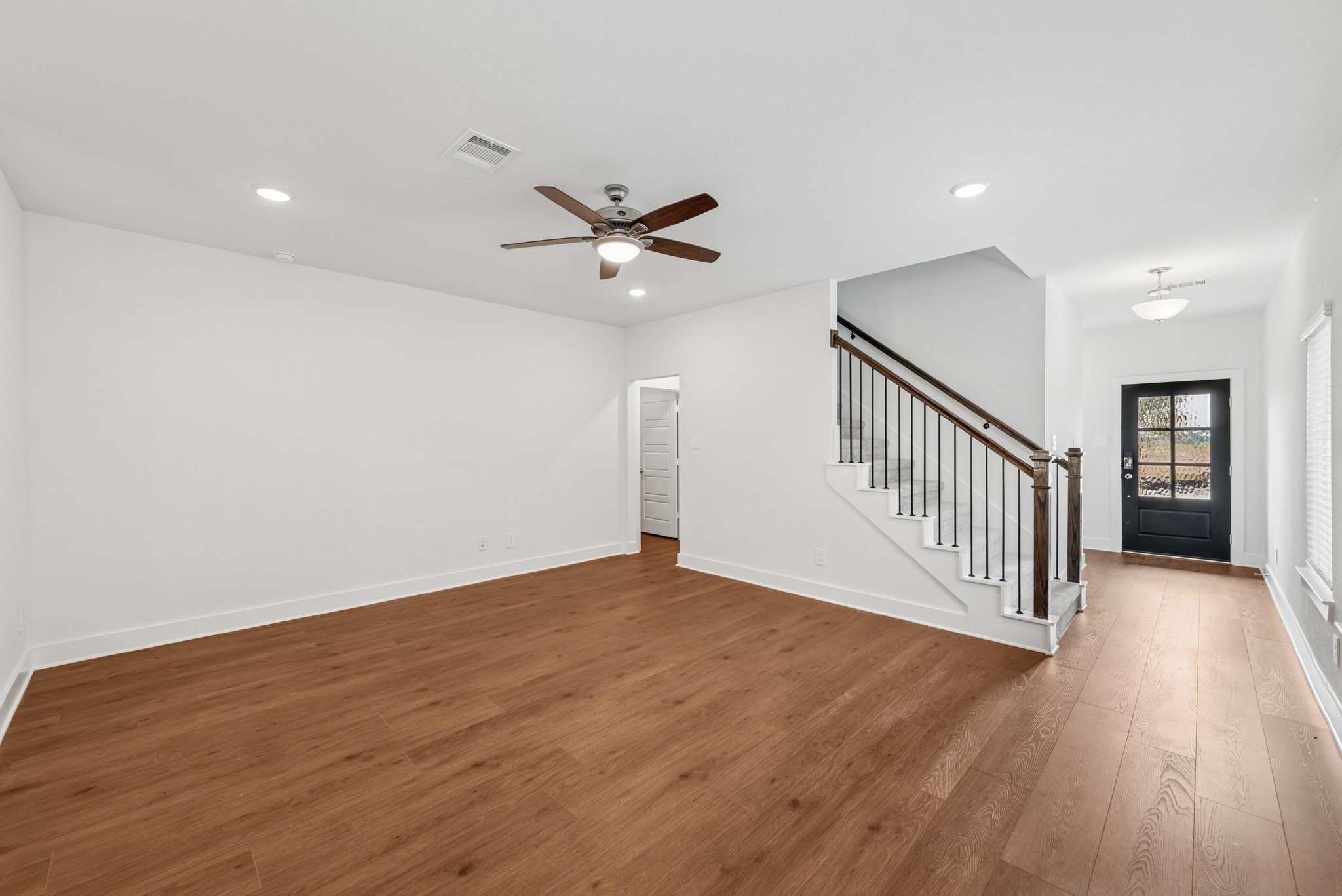 20518 Draper Road Tomball, TX 77377 - Photo 7 of 46 an empty room with wooden floor fan and windows