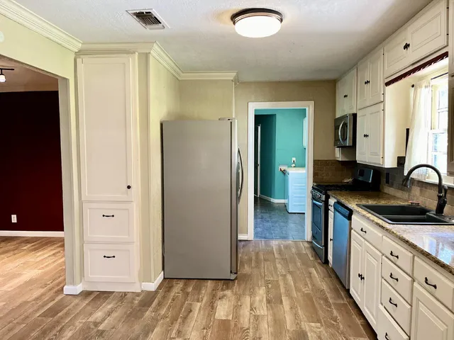 a kitchen with granite countertop a sink and cabinets