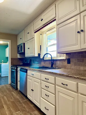 a kitchen with cabinets appliances and a sink