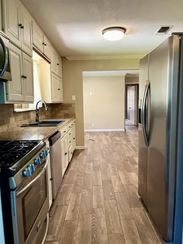 a kitchen with stainless steel appliances granite countertop a stove a sink and a refrigerator