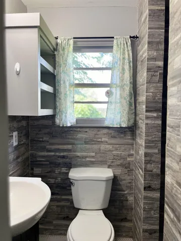 a bathroom with a toilet a sink and a window