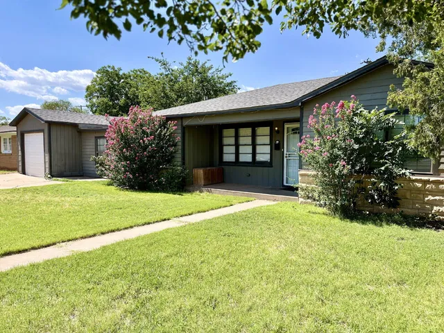 a view of a house with backyard and garden