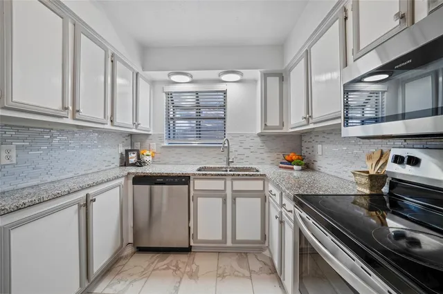 a kitchen with stainless steel appliances granite countertop a stove sink and cabinets