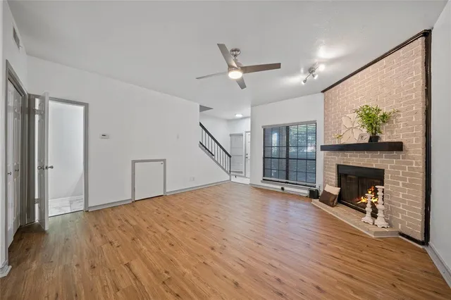 a view of empty room with wooden floor and fireplace