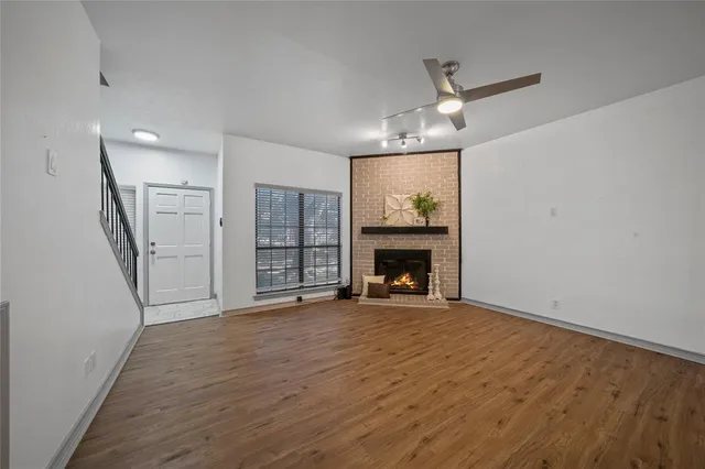 a view of an empty room with a fireplace and a window