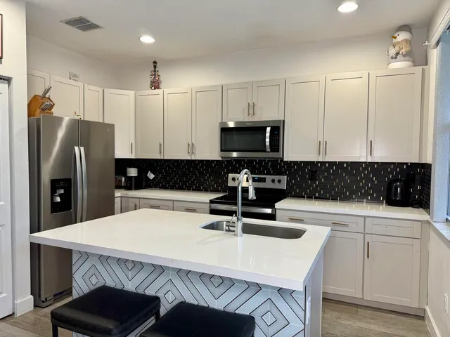 a kitchen with a sink a refrigerator and cabinets