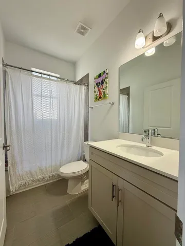 a bathroom with a double vanity sink toilet and a mirror