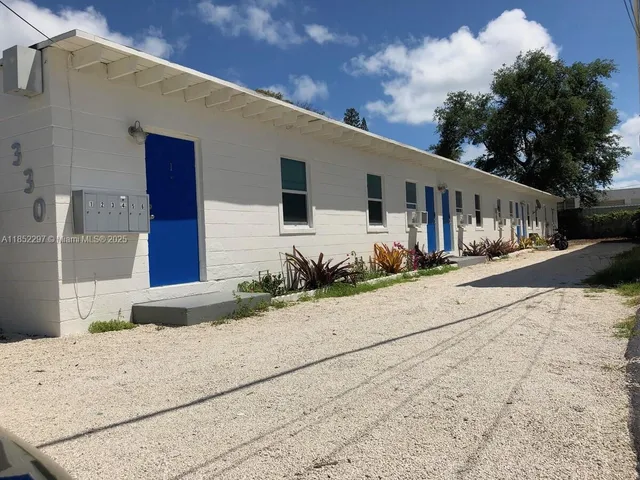 a front view of a house with a yard and potted plants