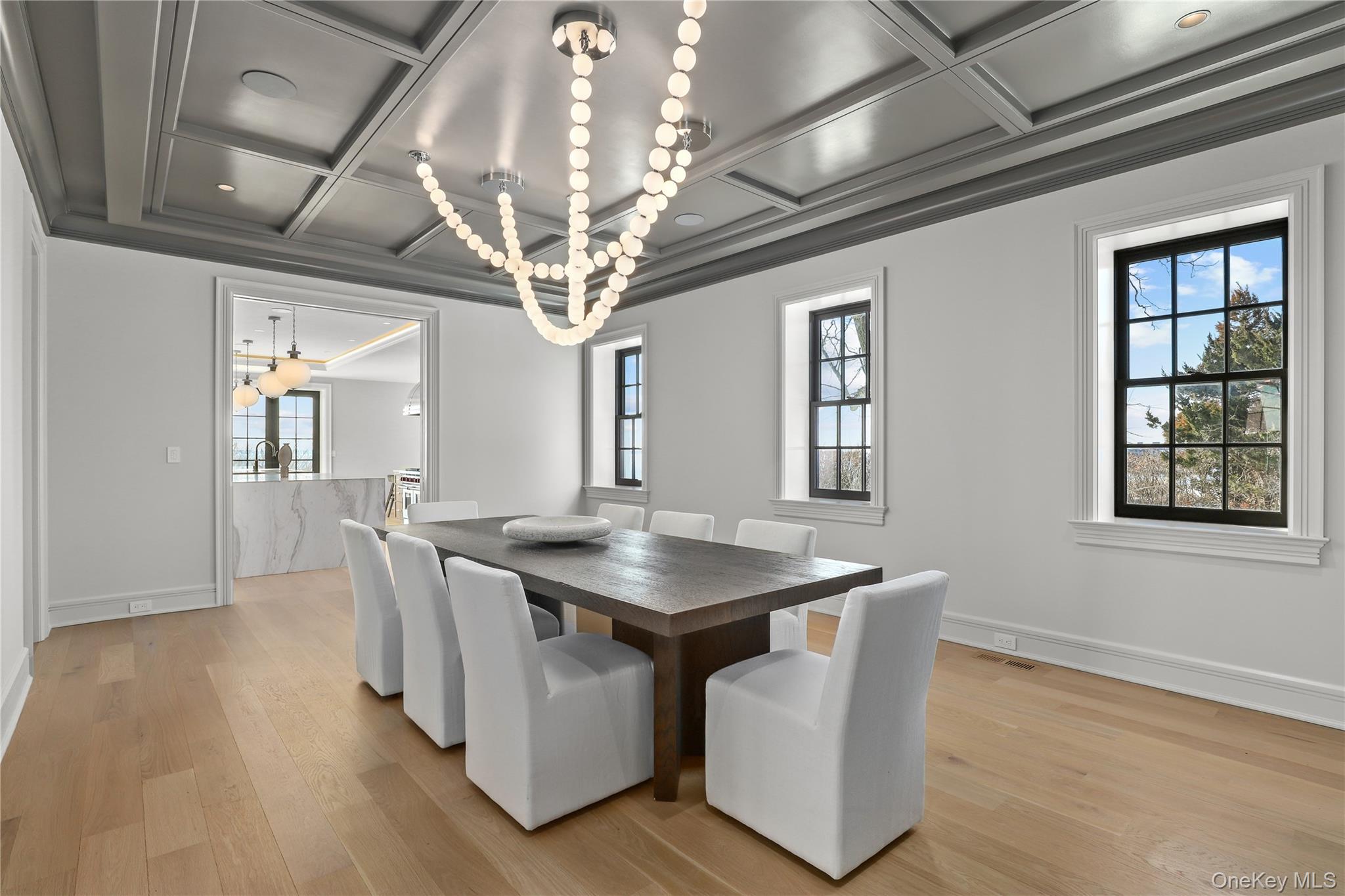 104 Premium Point Larchmont, NY 10538 - Photo 16 of 41 a dining room with wooden floor a chandelier a wooden table and chairs