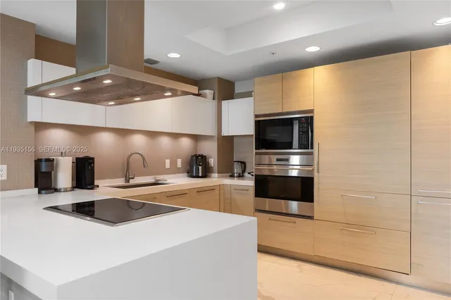 a kitchen with stainless steel appliances a stove a sink and a refrigerator
