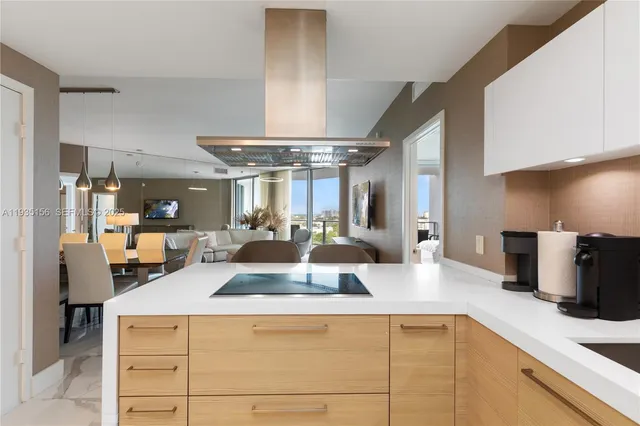 a view of living room with stainless steel appliances kitchen island granite countertop a table chairs in it