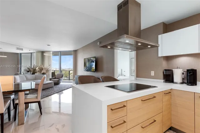 a kitchen with stainless steel appliances a sink a stove a table and chairs