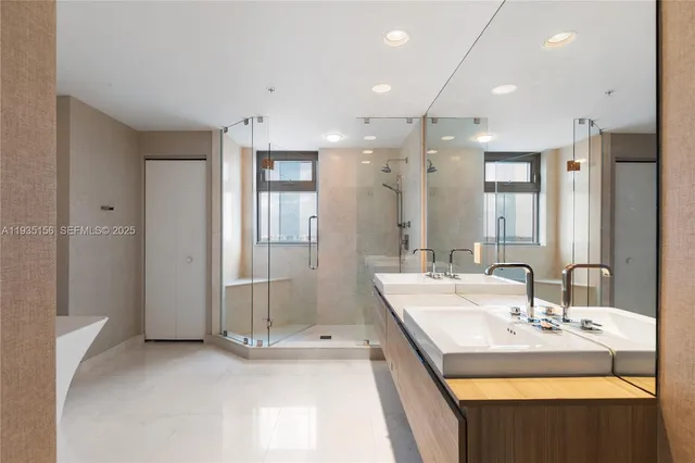 a bathroom with a tub sink shower and mirror