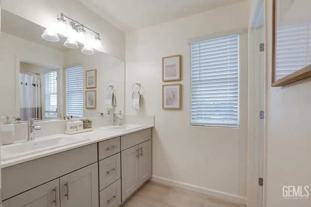 a bathroom with a double vanity sink and a mirror