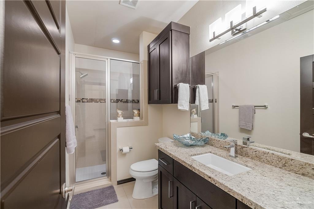 3104 Santa Monica Mission, TX 78572 - Photo 17 of 26 a bathroom with a granite countertop sink toilet and shower