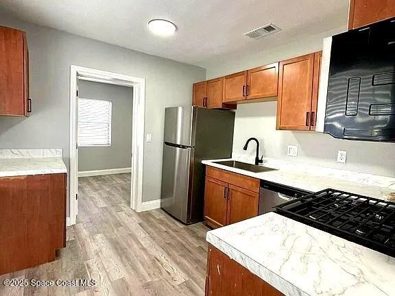 a kitchen with stainless steel appliances a sink stove and refrigerator