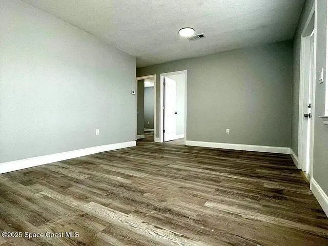a view of a room with wooden floor and window