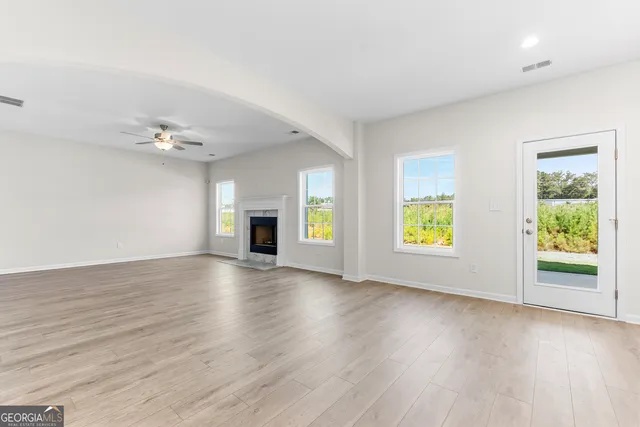 a view of an empty room with a kitchen and a window