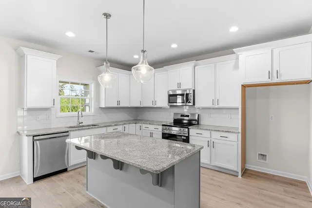 a kitchen with granite countertop white cabinets and a sink