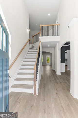 a view of staircase with railing and white walls