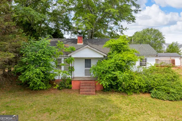 a view of a house with a yard and tree s