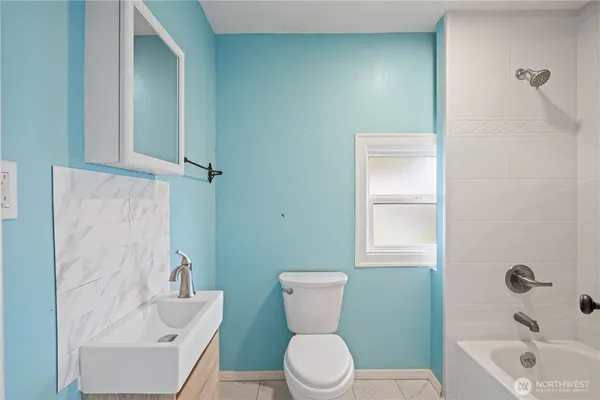 a white toilet sitting next to a bath tub