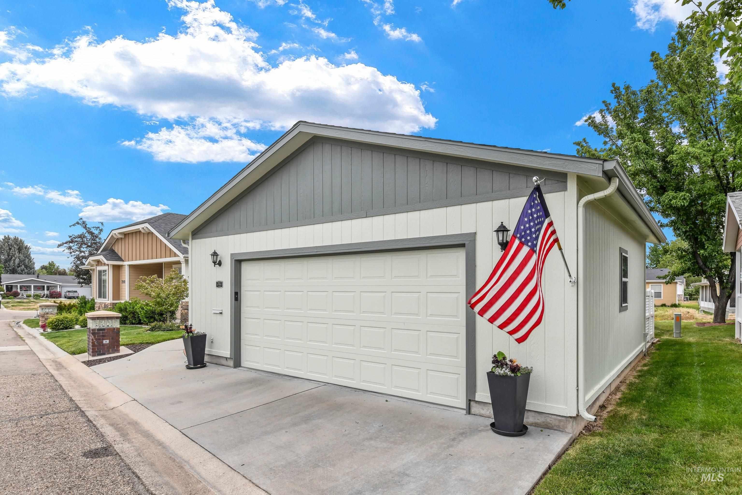 421 South Curtis Road, Unit 202 202 Boise, ID 83705 - Photo 26 of 41 Private outdoor patio featuring patterned paver flooring, a retractable awning, and a decorative trellis with artificial greenery