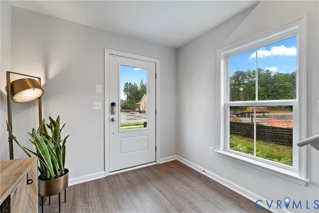 a view of empty room with wooden floor and window