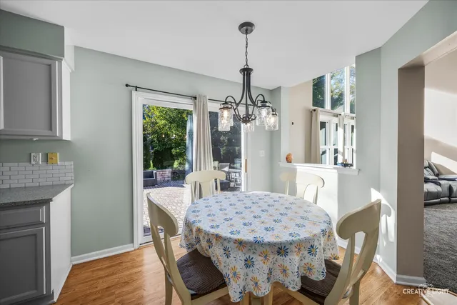 a dining room with furniture a chandelier and wooden floor