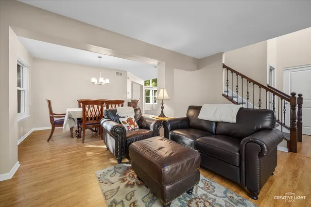 a living room with furniture and a dining table with wooden floor