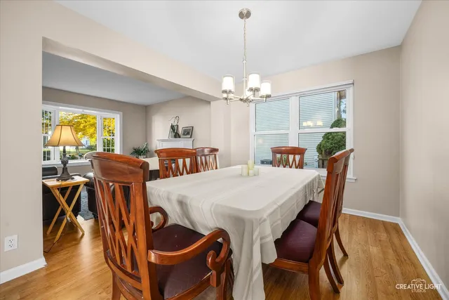 a view of a dining room with furniture wooden floor and chandelier