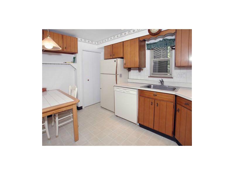 Kitchen. Kitchen with custom-sized table, window overlooks backyard.  Recessed lighting accents and pocket door.