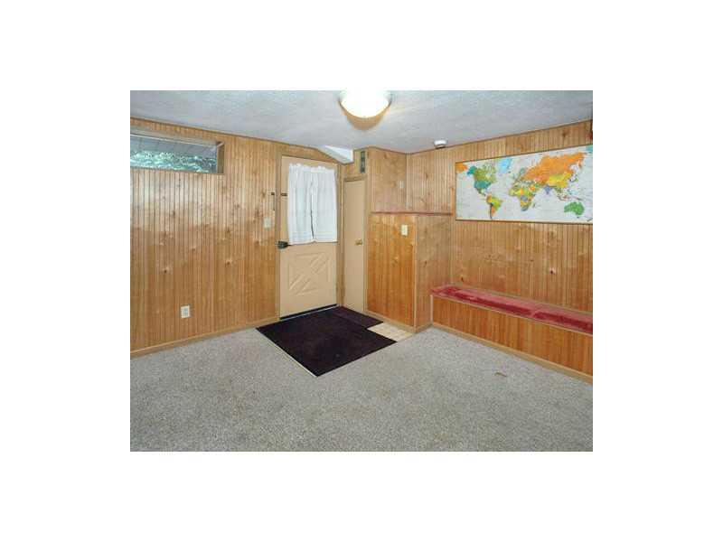 315 Edgewood Road Forest Hills, PA 15221 - Photo 10 of 14 Den/Family/Great Room. The lower-level game room features paneling, built-in benches with storage, and a door leading to the driveway and backyard.