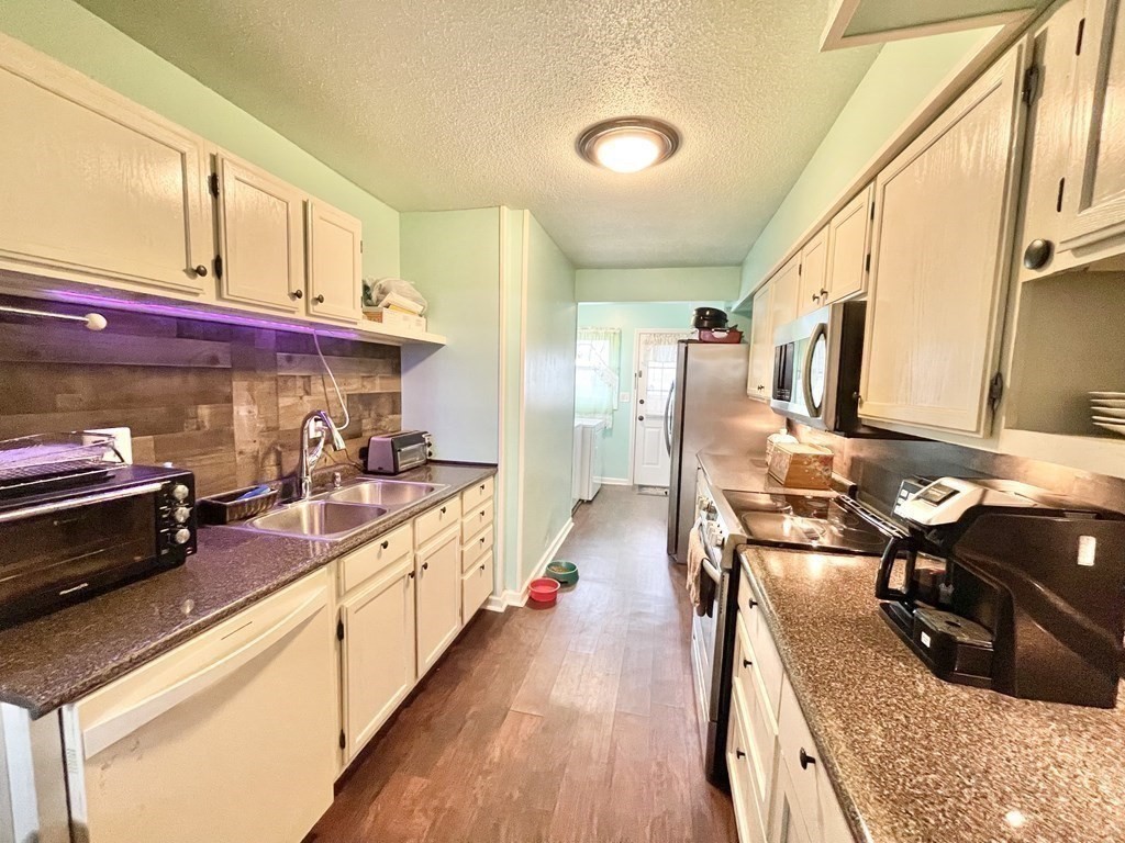 1107 James Street, Unit 1107 Chicopee, MA 01022 - Photo 9 of 26 a large kitchen with stainless steel appliances kitchen island granite countertop a large counter top a stove and a sink