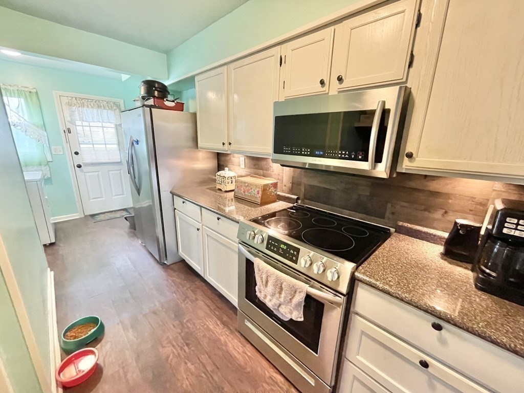 1107 James Street, Unit 1107 Chicopee, MA 01022 - Photo 10 of 26 a kitchen with stainless steel appliances granite countertop a stove a microwave and a hard wood floor
