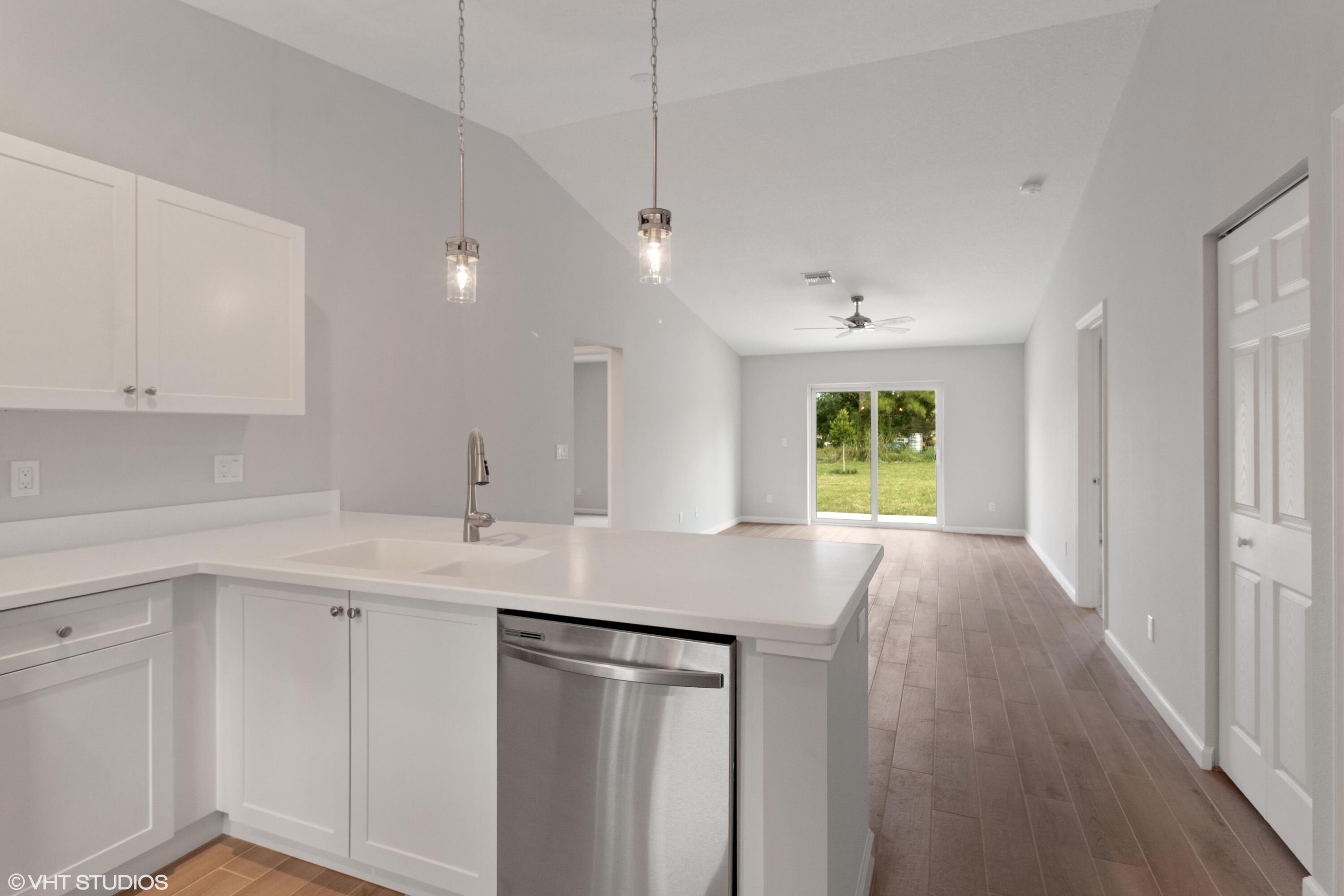 4910 Southeast Jack Avenue Stuart, FL 34997 - Photo 3 of 14 a kitchen with a sink stove and cabinets