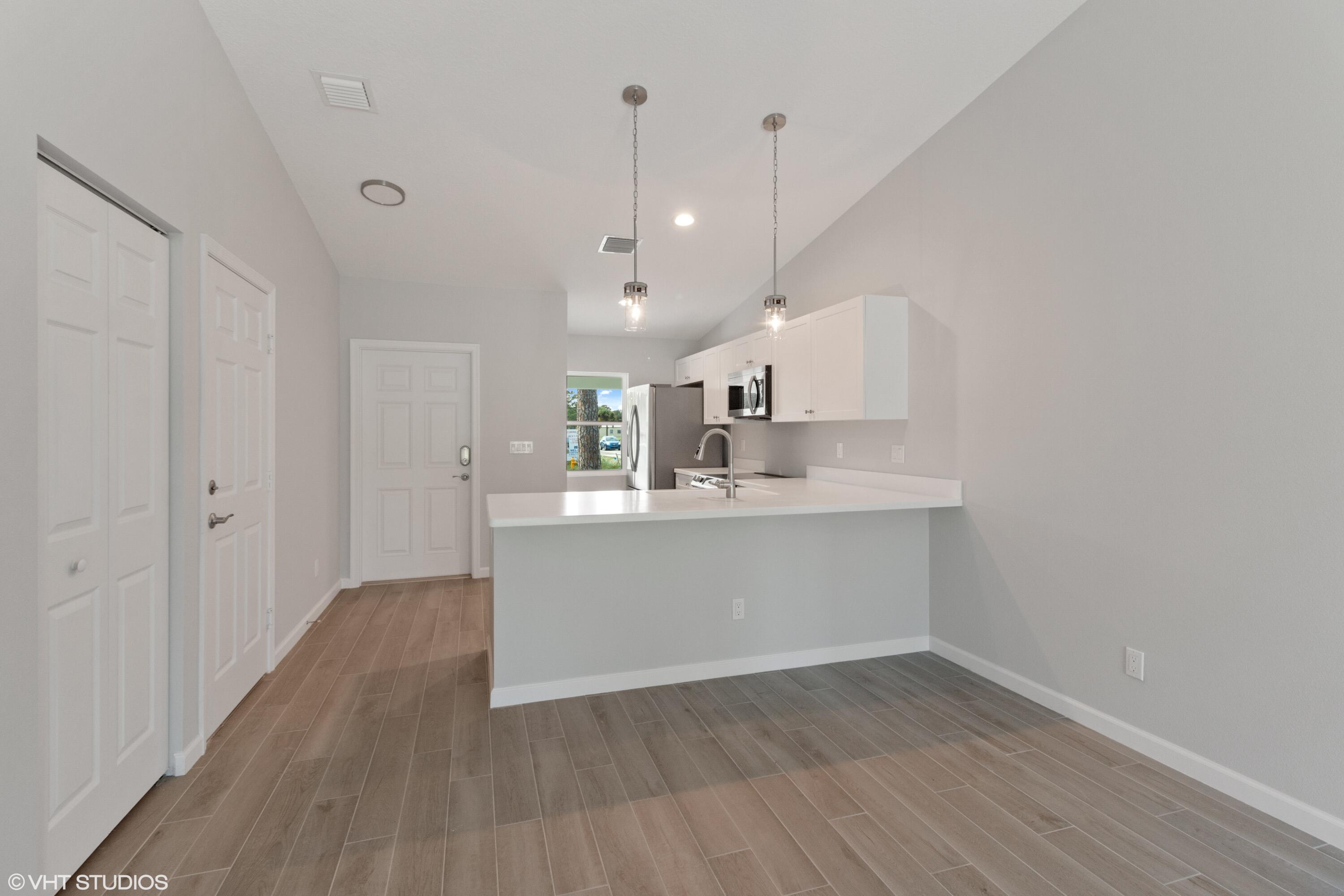 4910 Southeast Jack Avenue Stuart, FL 34997 - Photo 6 of 14 a view of a kitchen with wooden floor