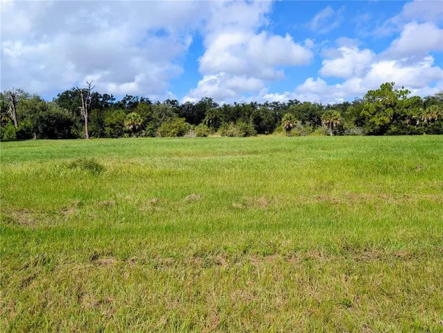 a view of a green field with wooden fence