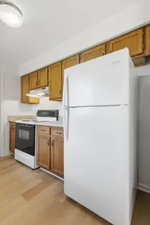 a white refrigerator freezer and a stove sitting inside of a kitchen
