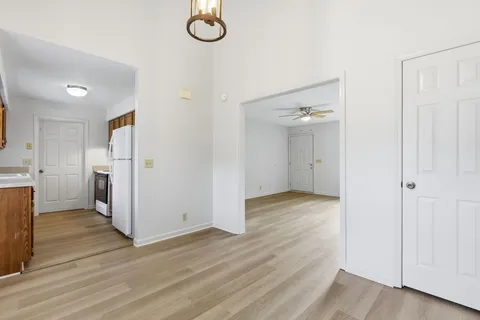 an empty room with wooden floor and white cabinet