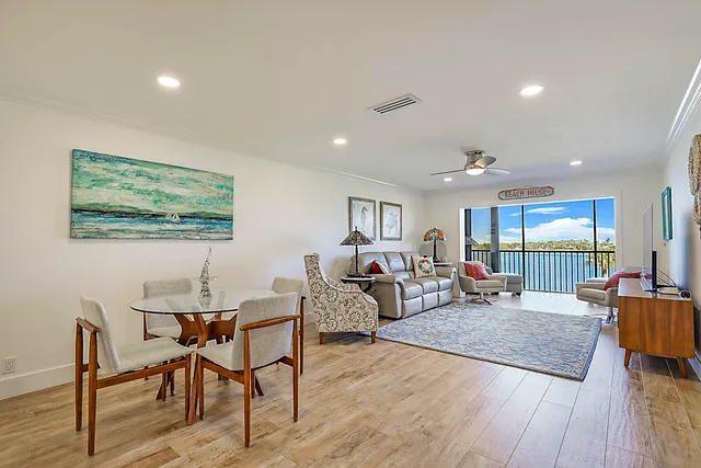 a living room with furniture a wooden floor and large window
