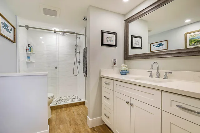 a bathroom with a shower sink and mirror