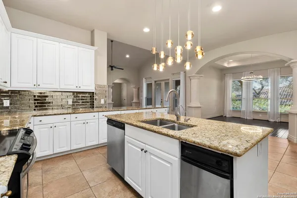 a kitchen with granite countertop kitchen island a sink appliances and a counter top space