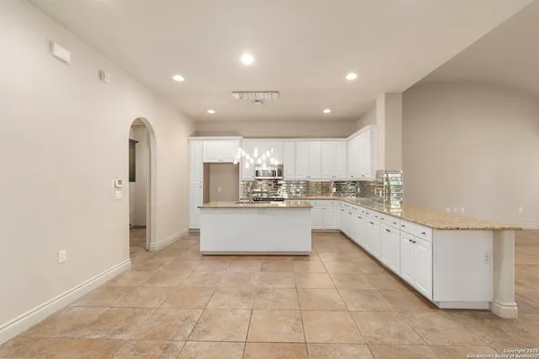 a large white kitchen with a large window and stainless steel appliances